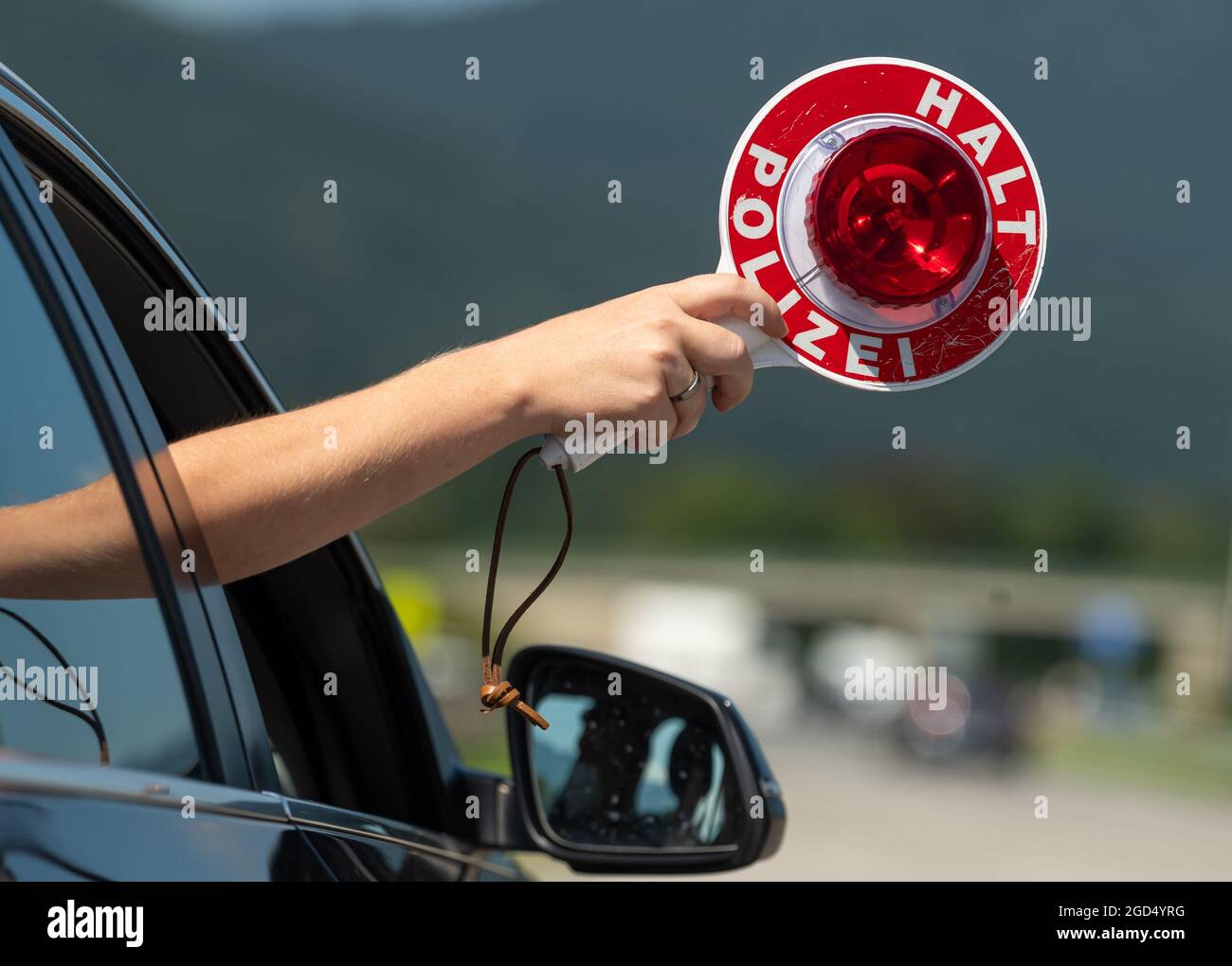 Piding, Deutschland. August 2021. Am Checkpoint Piding Nord, A8, in Richtung München, wird eine Polizeipfanne aus einem zivilen Polizeifahrzeug herausgehalten. Am Morgen besuchte der bayerische Innenminister den Schleierfahnder vor Ort, um sich über die Corona-Kontrollen von Reisenden zu informieren, die nach Deutschland zurückkehren. Kredit: Peter Kneffel/dpa/Alamy Live Nachrichten Stockfoto