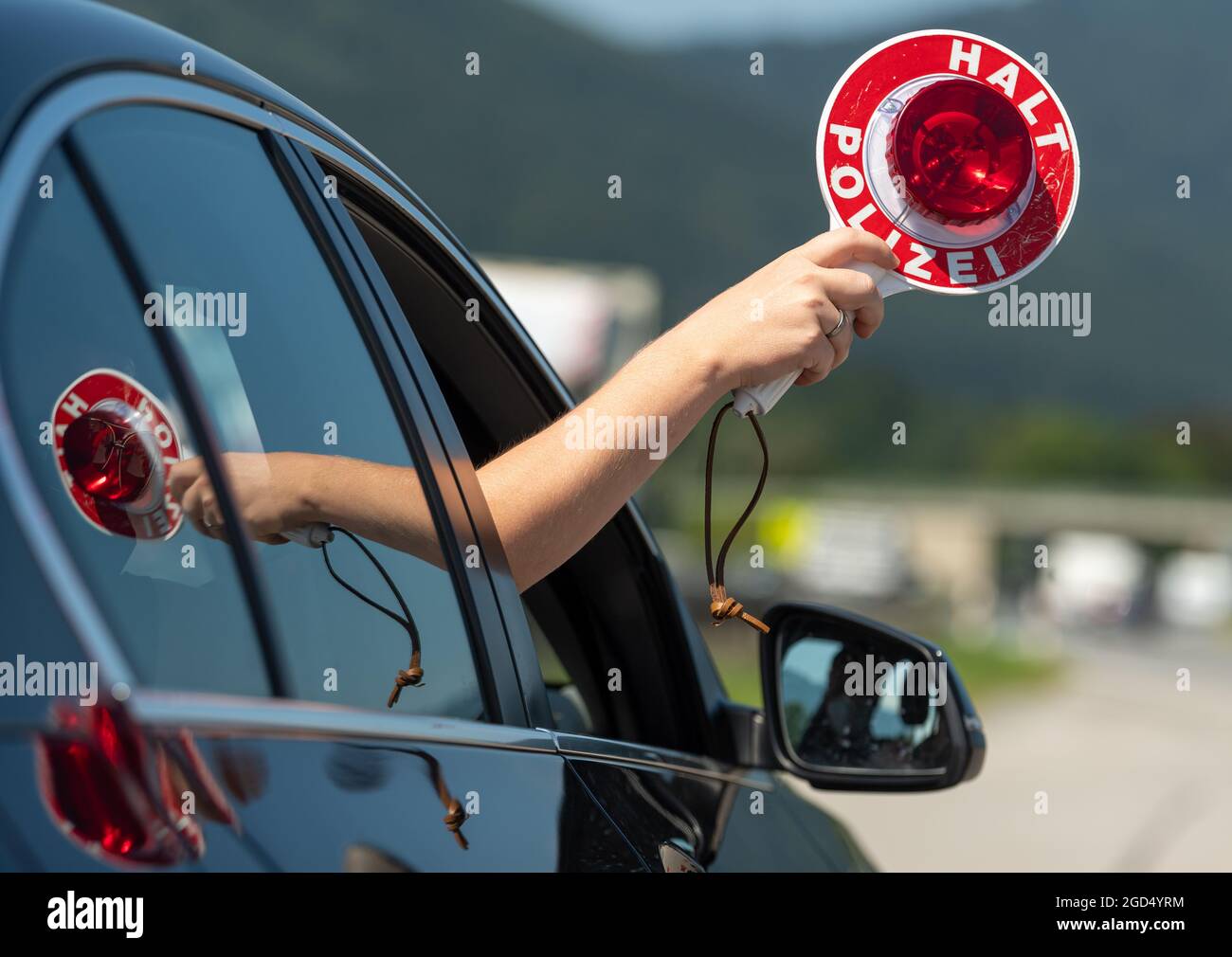 Piding, Deutschland. August 2021. Am Checkpoint Piding Nord, A8, in Richtung München, wird eine Polizeipfanne aus einem zivilen Polizeifahrzeug herausgehalten. Am Morgen besuchte der bayerische Innenminister den Schleierfahnder vor Ort, um sich über die Corona-Kontrollen von Reisenden zu informieren, die nach Deutschland zurückkehren. Kredit: Peter Kneffel/dpa/Alamy Live Nachrichten Stockfoto