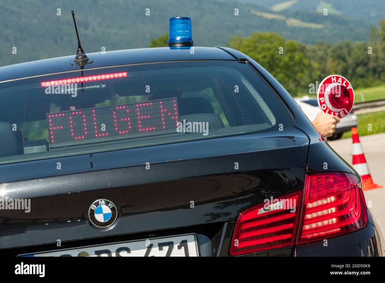 11. August 2021, Bayern, Piding: Am Checkpoint Piding Nord, A8, Richtung München, wird eine Polizeipfanne aus einem Polizeizivilfahrzeug herausgehalten. Am Morgen besuchte der bayerische Innenminister den Schleierfahnder vor Ort, um sich über die Corona-Kontrollen von Reisenden zu informieren, die nach Deutschland zurückkehren. Foto: Peter Kneffel/dpa Stockfoto