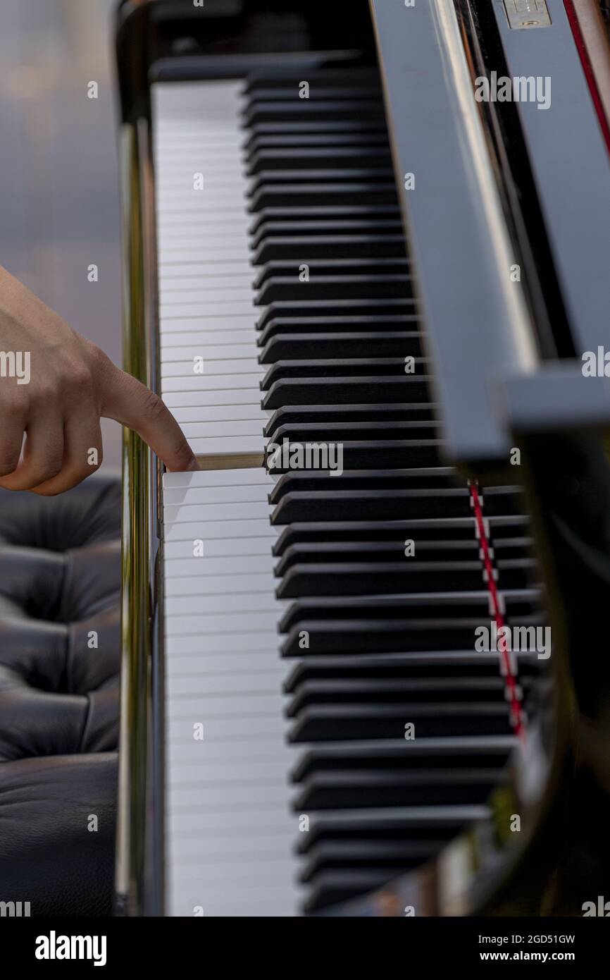 Vertikale Aufnahme eines Fingers, der eine Klaviertaste drückt Stockfoto