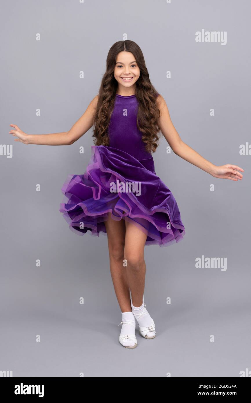 Ziemlich glücklich Kind mit langen lockigen Haaren tanzen im Ballsaal Kleid in voller Länge, Performer Stockfoto