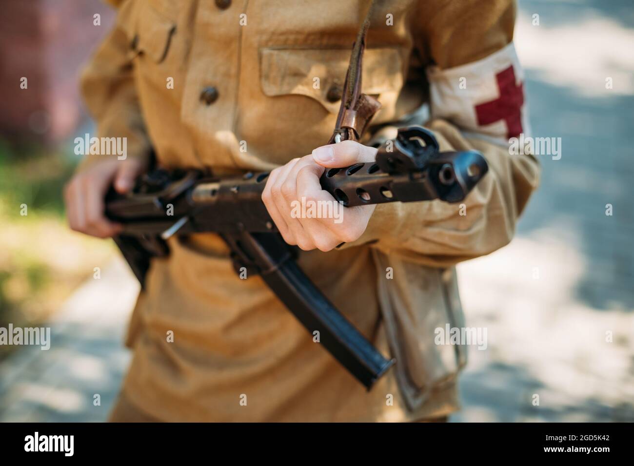 Nicht identifizierter Rekonstrukteur, der als sowjetische Militärkrankenschwester mit einem Maschinengewehr in der Hand gekleidet ist Stockfoto