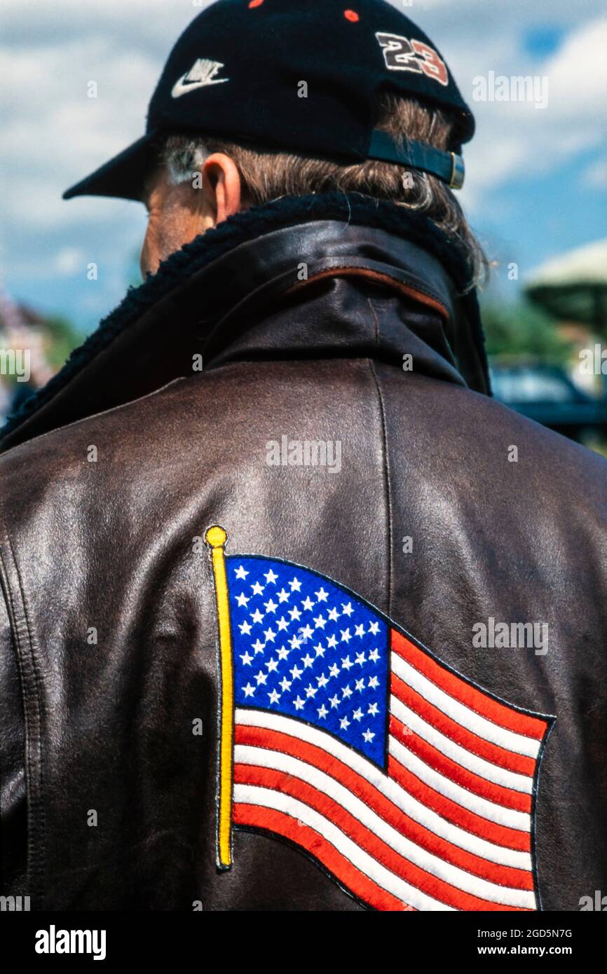 Amerikanischer Patriot in einer Bomberjacke aus Leder mit Stars and Stripes auf der Rückseite und einer Baseballmütze, London, Großbritannien Stockfoto