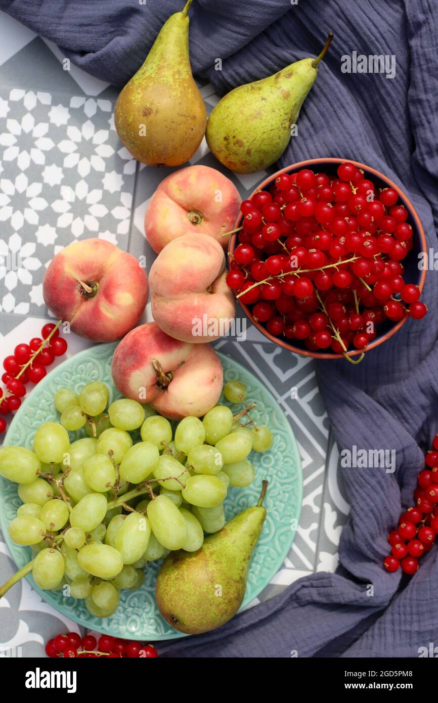 Stillleben mit Früchten und Beeren. Bio-Beeren und Obst auf einem Tisch. Gartenernte Nahaufnahme Foto. Birnen, Pfirsiche, rote Johannisbeere, Heidelbeere Stockfoto