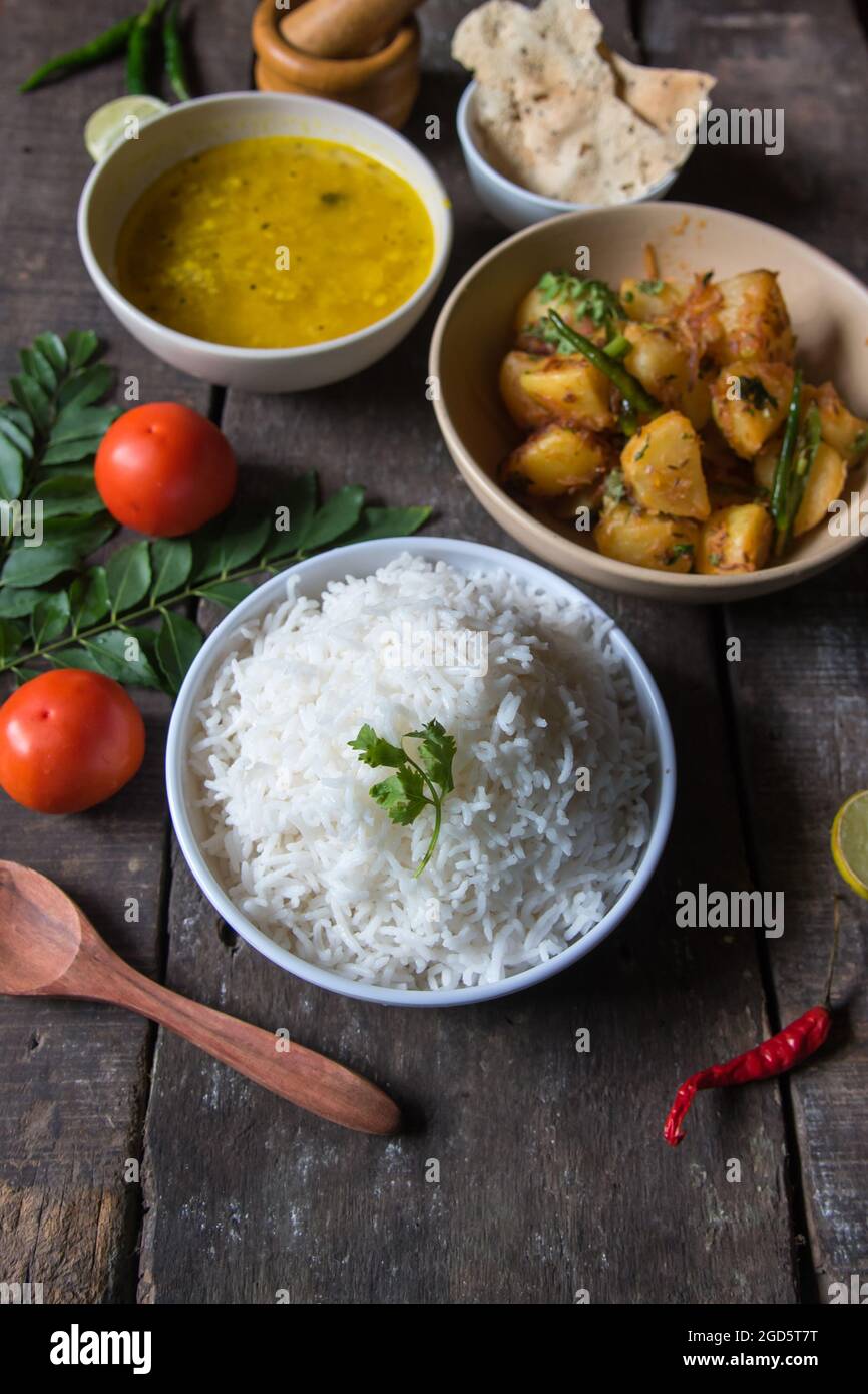 Gekochte indische Lebensmittel Reis, Kartoffelbraten und Dal Hintergrund. Nahaufnahme, selektiver Fokus. Stockfoto