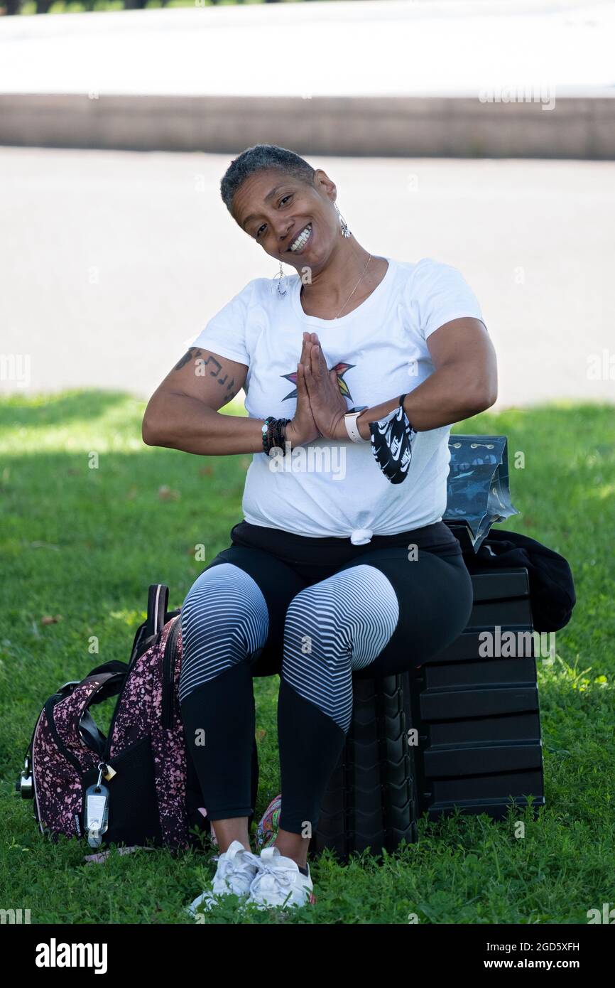 Porträt eines Yoga- und Wellnesslehrers mittleren Alters, der eine Klasse im Flushing Meadows Corona Park in Queens unterrichtet. Stockfoto