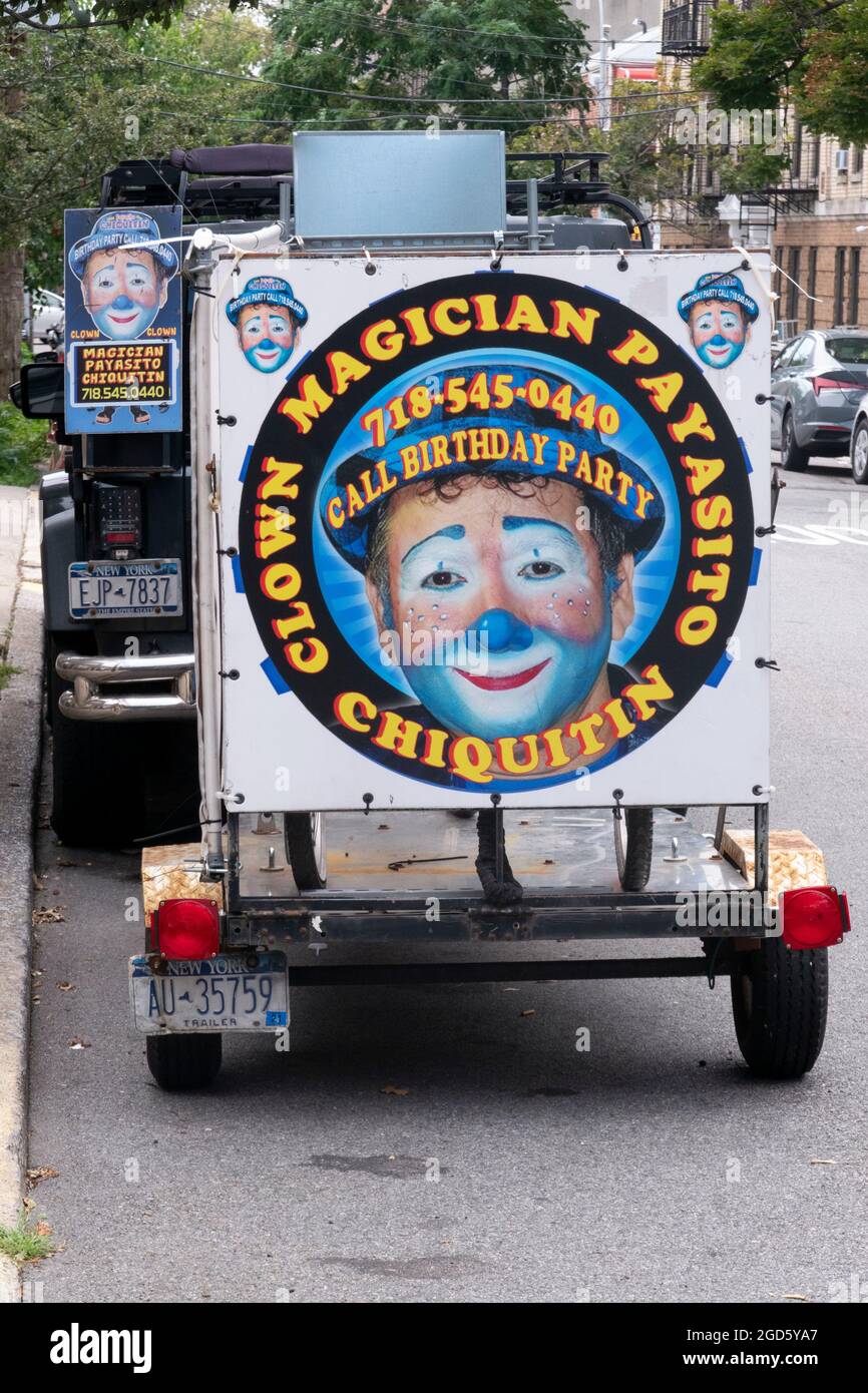 Ein SUV und Trailer mit farbenfrohen Anzeigen für Payasito Chiquitin, einen spanischsprachigen Clown, Zauberer und Entertainer. In Astoria, Queens, New York. Stockfoto