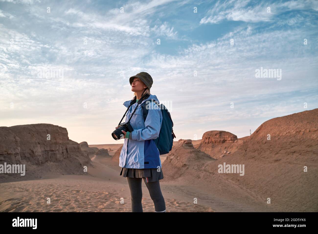 asiatische Fotografin, die die Landschaft in der wüste gobi mit ihren Yardang-Landformen betrachtet Stockfoto