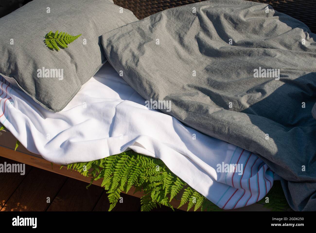 Holzfarnblätter unter dem Bettlaken. Schlafen auf Farnblättern. Tradizionales antiarthritisches Mittel. Stockfoto