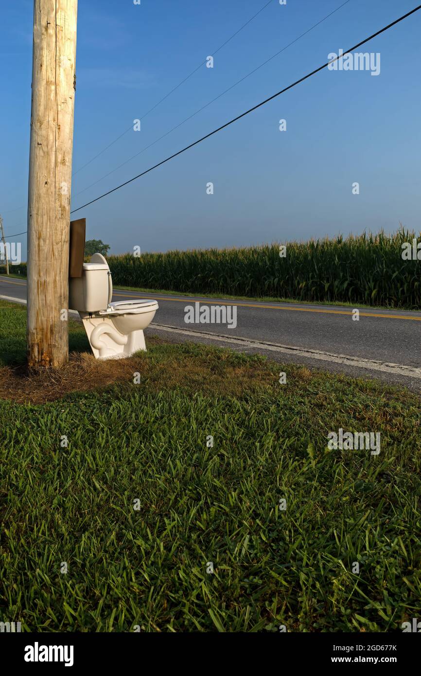 In der frühen Morgensonne halten die Toiletten an einer ländlichen Landstraße an. Stockfoto