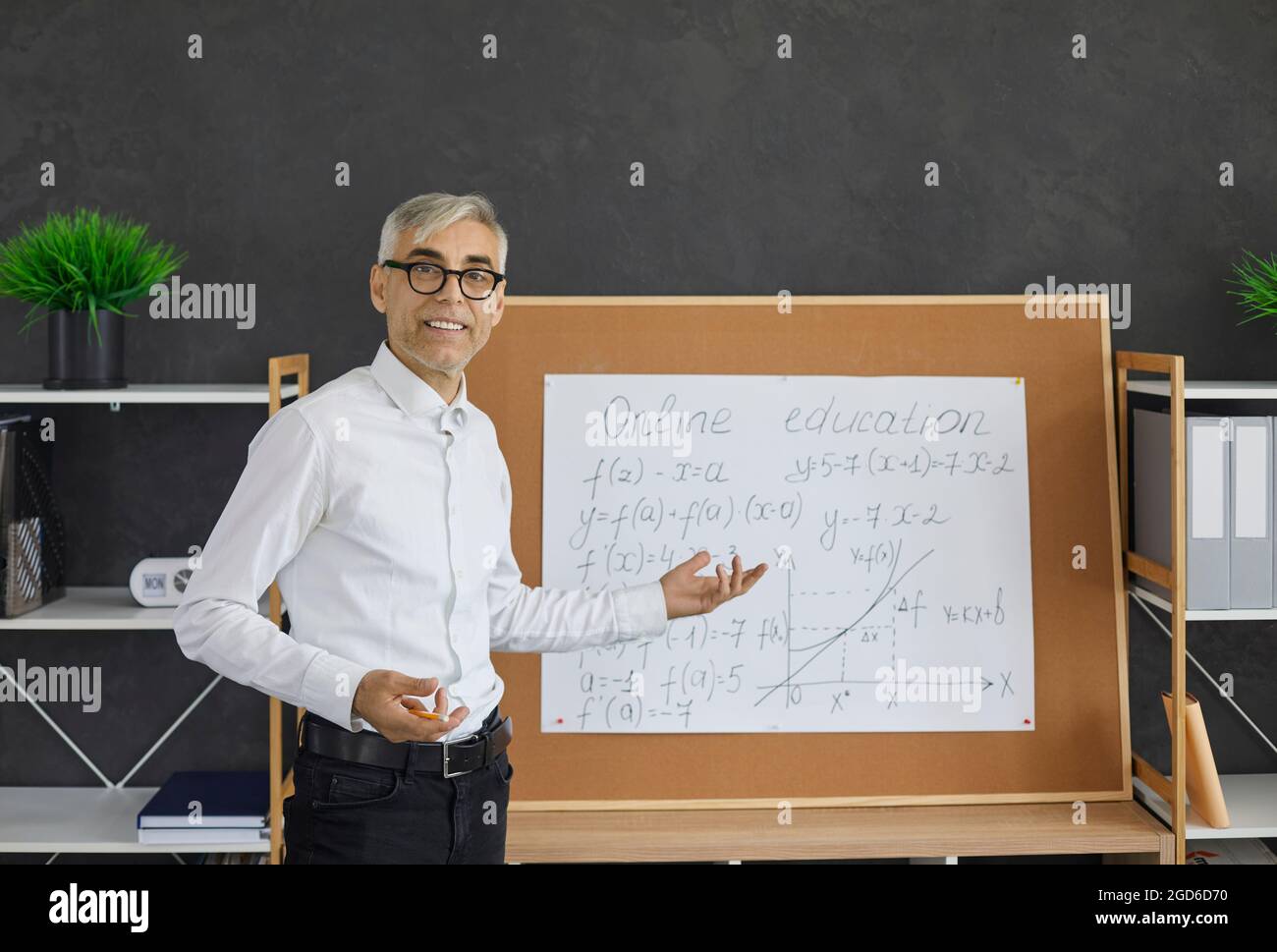 Porträt eines Mathematiklehrers, der während des Online-Unterrichts vor dem Klassenzimmer steht Stockfoto