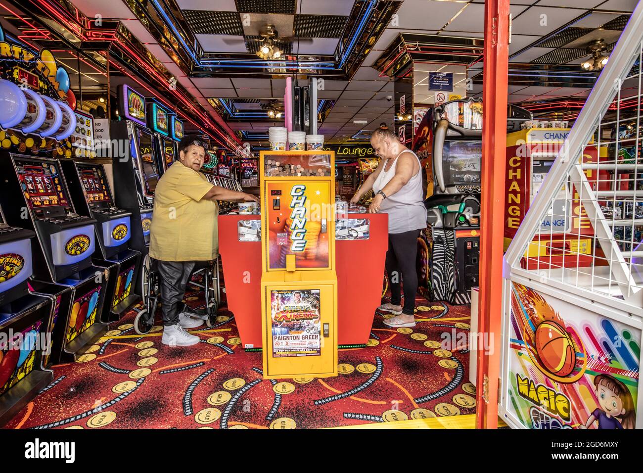Menschen, die die Spielhallen genießen, die Spielautomaten im Badeort Paignton an der Küste von South Devon, England, Großbritannien, spielen Stockfoto