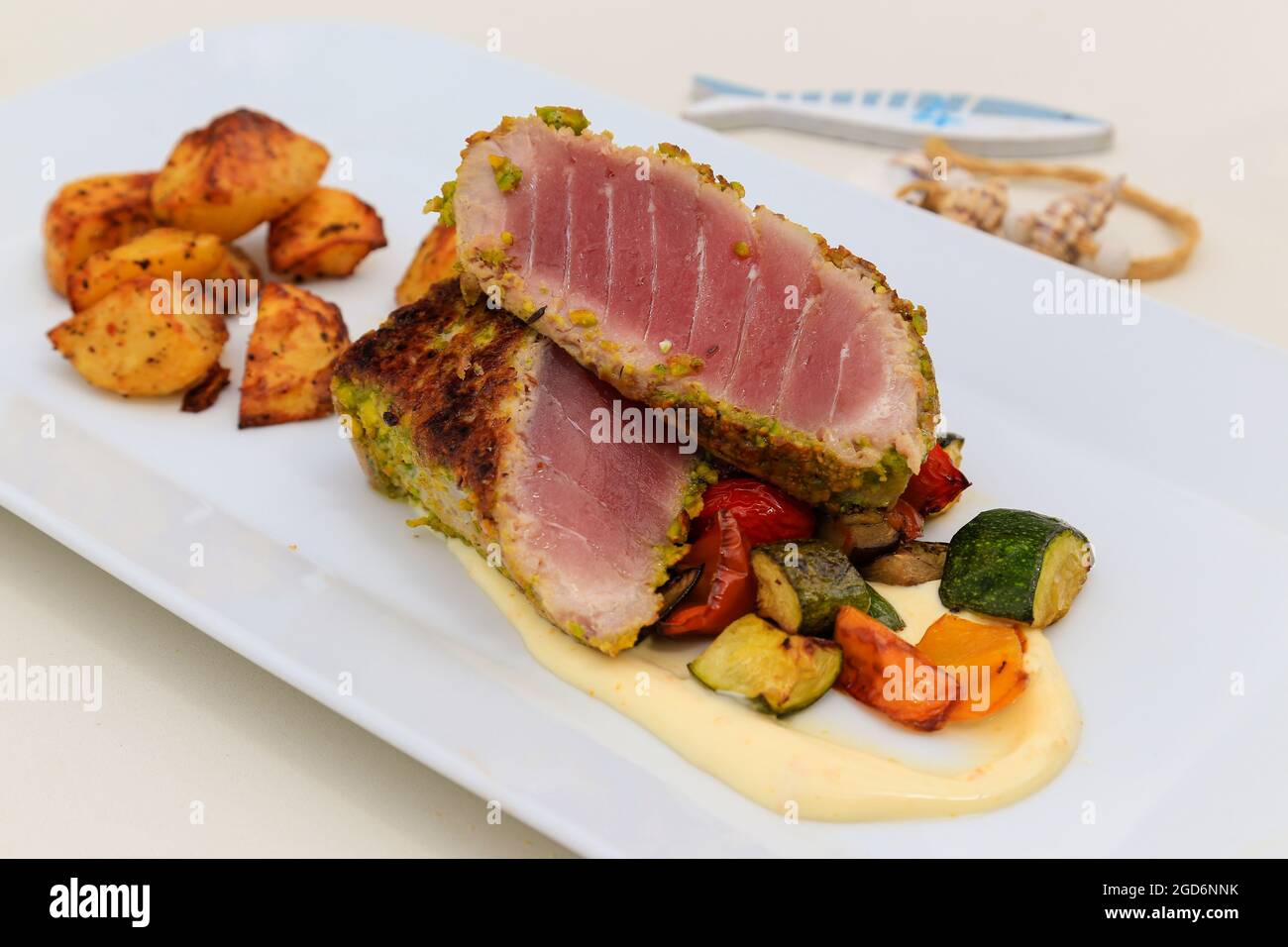 Platte mit gebratenen Thunfisch mit einer pistacchio-Kruste und Gemüse. Stockfoto