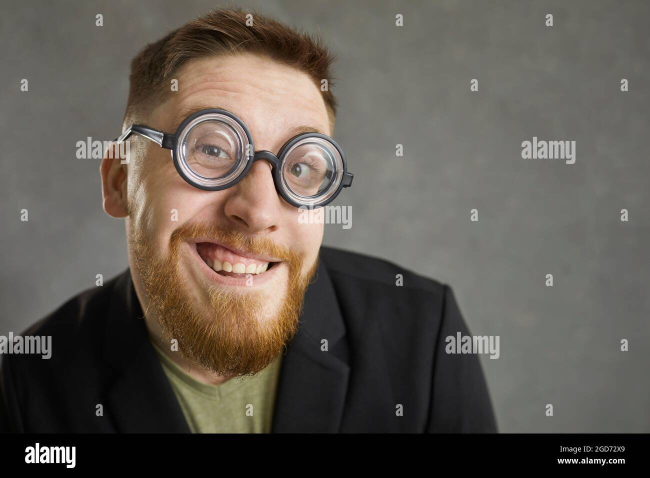 Nahaufnahme Porträt eines lustigen verrückten Nerds in runden Brillen lächelt auf die Kamera Stockfoto