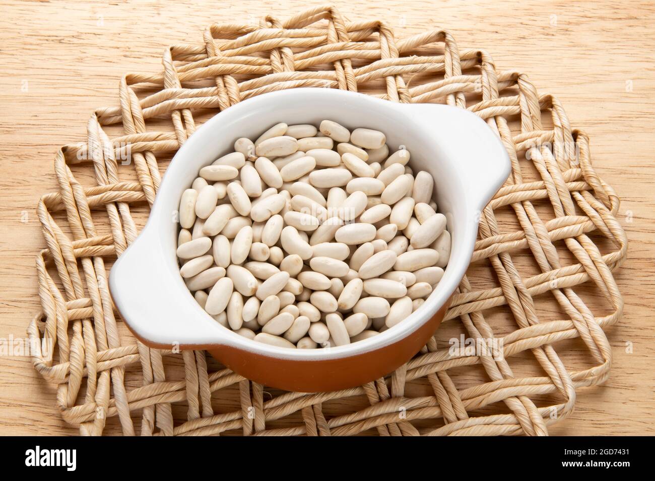 Glas mit Getreide - Rohzutat für die Zubereitung von Gerichten - Weiße Bohne Stockfoto