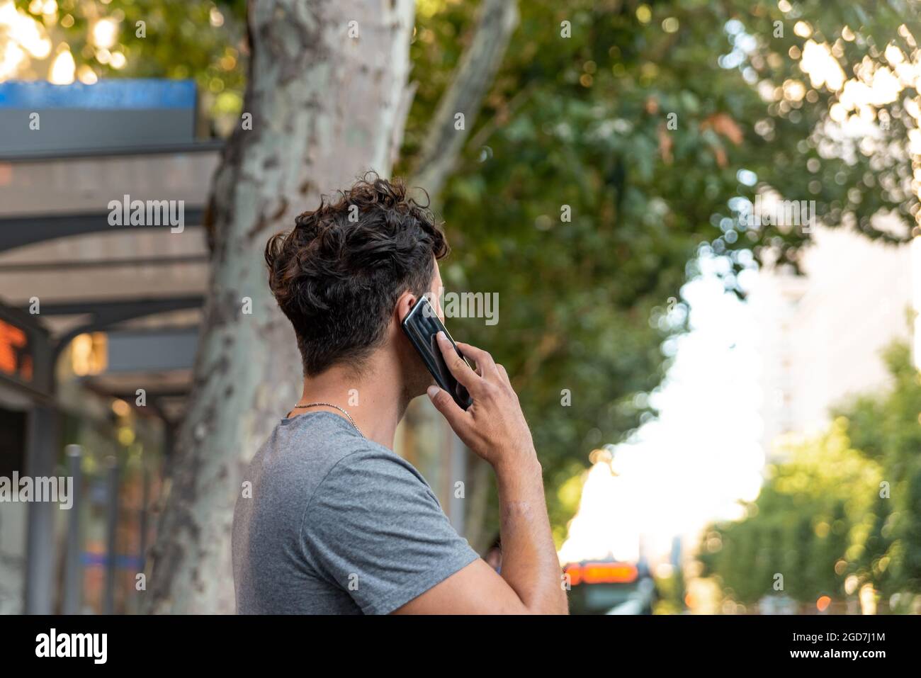 Junger latein in der Stadt, der mit dem Handy spricht. Stockfoto