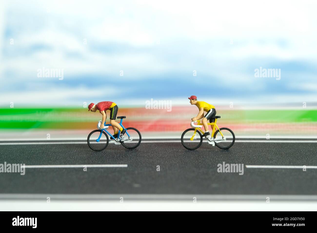 Miniatur Menschen Spielzeug Figur Fotografie. Fahrrad mit schneller Bewegung. Ein Biker, der mit hoher Geschwindigkeit auf einer Strecke radelt. Bildfoto Stockfoto