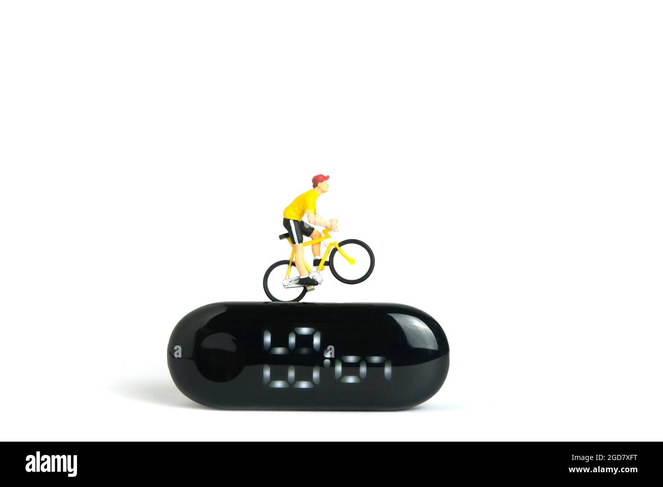 Miniatur Menschen Spielzeug Figur Fotografie. Fahrrad-Radtrainer und Tracing Gesundheit App. Ein Biker, der über der Smartwatch radelt, isoliert auf weißem Hintergrund. Stockfoto