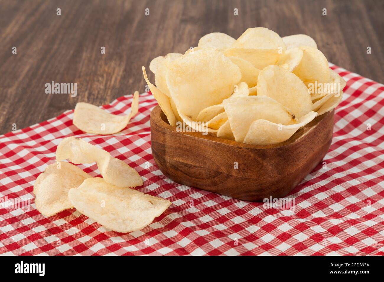 Holzschüssel Mit Leckeren Kartoffelchips; Foto Auf Holzhintergrund Stockfoto