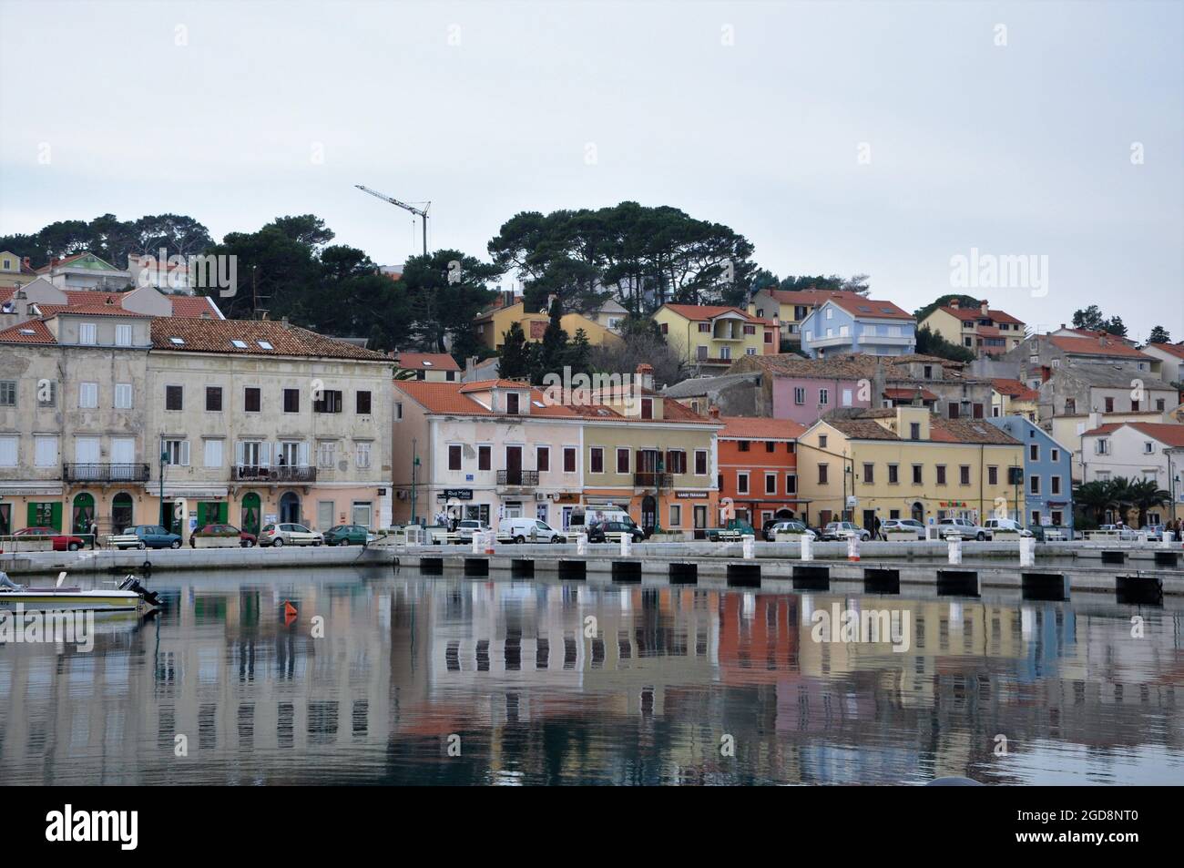 Stadtbild bei Tageslicht bei Reflexion in der Lagune der Insel Mali Losinj. Mittelmeer-Stadt Mali Losinj Küste Reflexionen auf dem Meer. Stockfoto