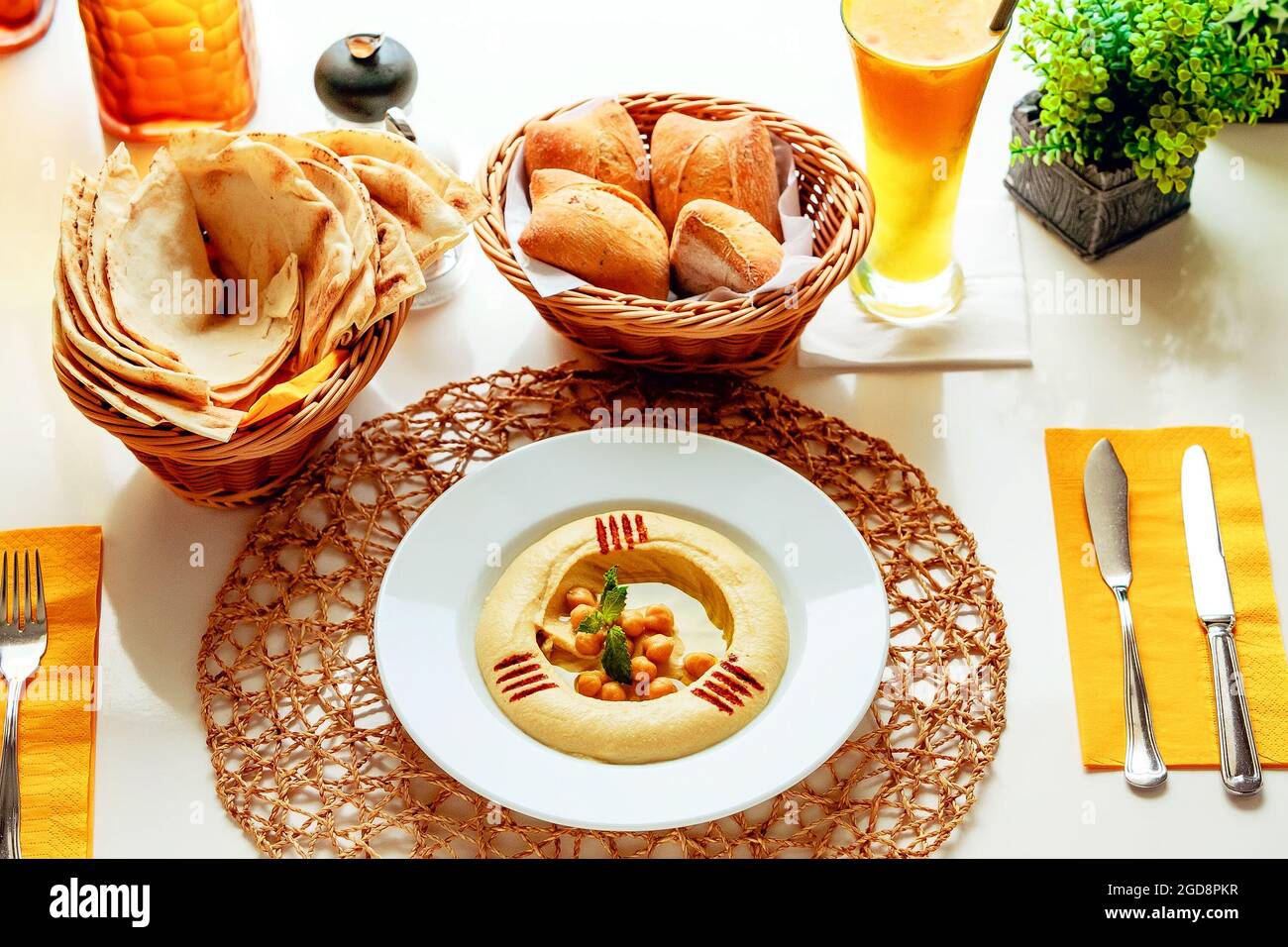 Klassischer Hummus mit zwei Sorten Brot und Orangensaft Stockfoto