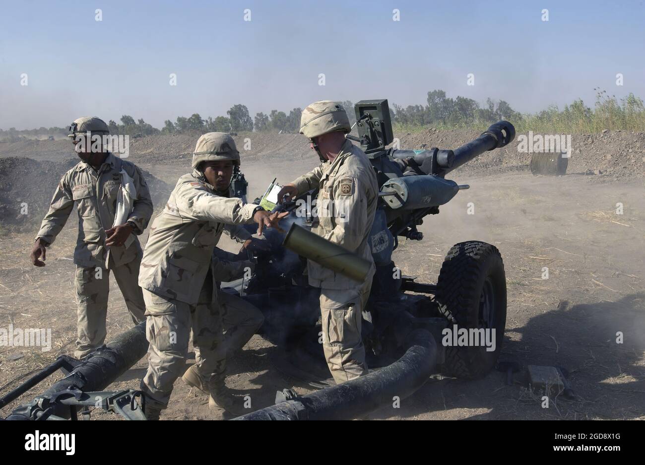 US Army (USA) Specialist (SPC) Maaka Tuionetoa, 2-319th Airborne Field Artillery Regiment, wirft ein leeres Gehäuse ab, als Soldat, der seiner Einheit zugewiesen wurde, während einer Mission auf dem internationalen Flughafen Bagdad, Irak, während der Operation IRAQI FREEDOM, den 105mm runden M119A1 105mm Lightweight Towed Howitzer feuerte. (USAF-FOTO VON MSGT JAMES M. BOWMAN 030816-F-5586B-007) Stockfoto