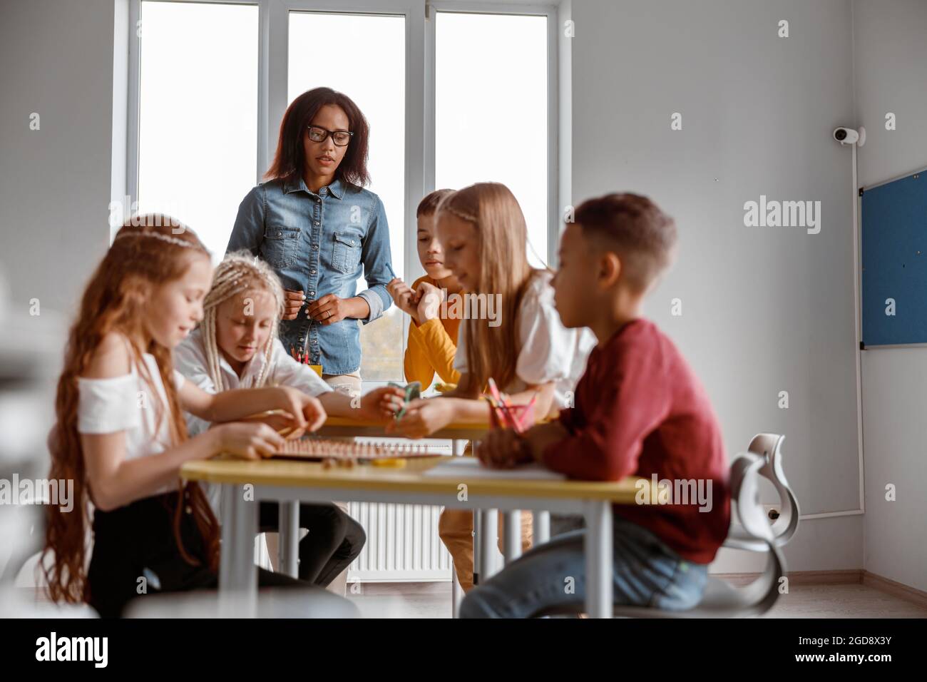 Glückliche Jungen und Mädchen mit hölzernen mathematischen Tablette Stockfoto