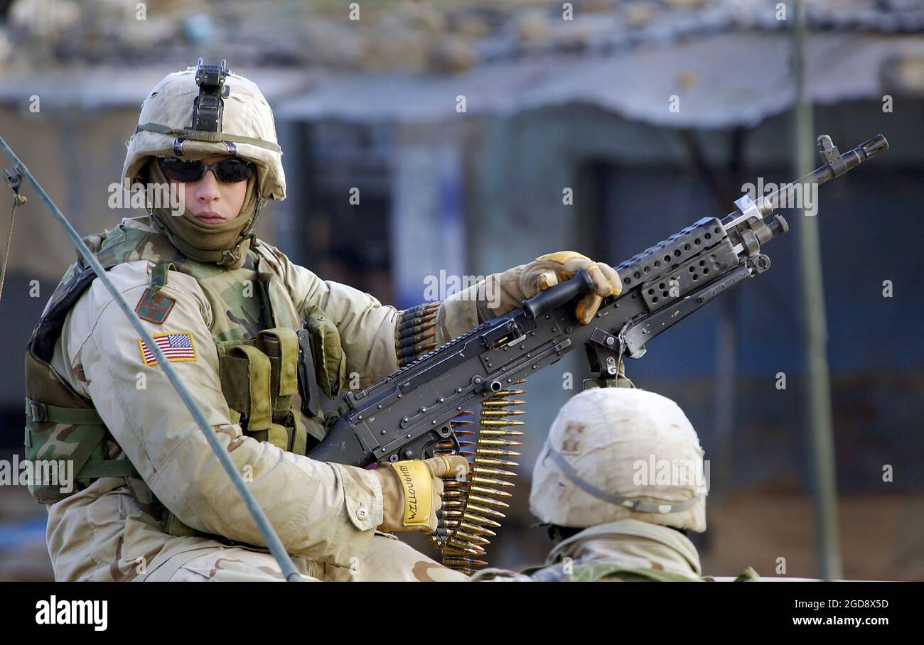 US Army (USA) Specialist Fourth Class (SFC) Willoughby, 173rd Airborne Brigade (ab BDE) bemannt ein FNMI 7.62 mm M240B Maschinengewehr, in einer Sicherheitsposition auf den Straßen von Al Hawijah im Rahmen der Operation Bajonet Lightning während der Operation IRAQI FREEDOM. Bajonettblitz ist eine gemeinsame Kordonoperation auf der Ebene der 173. Brigade, um Interessensgruppen zu lokalisieren und zu befragen, sowie eine Kraftvorstellung in der irakischen Stadt Al Hawijah. (USAF-FOTO VON SSGT JEFFREY A. WOLFE 031202-F-1798W-018) Stockfoto