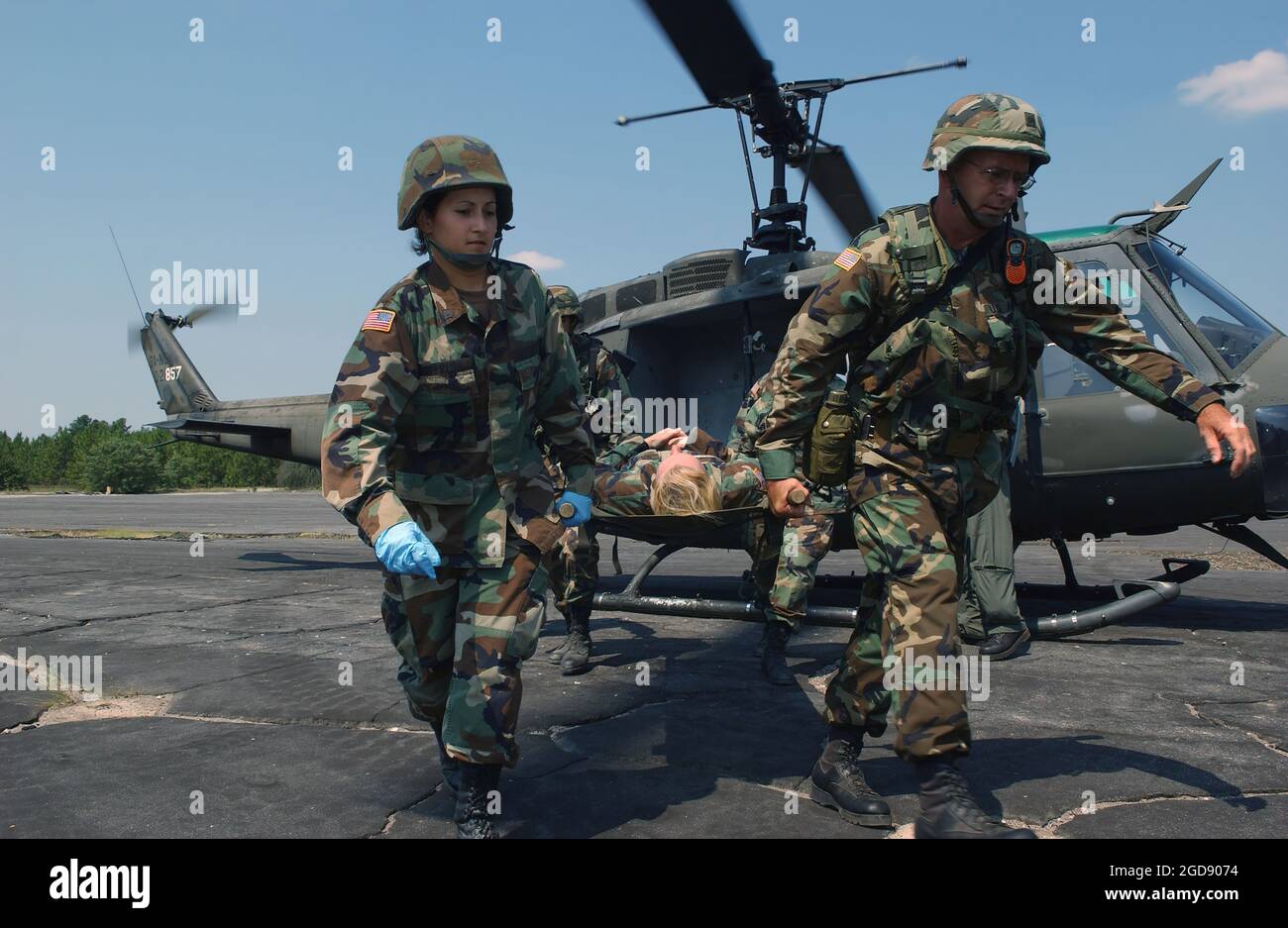 MEDIZINISCHES Personal DER US Army (USA) trägt einen Patienten aus einer Bahre eines US UH-1 Iroquois Huey Air Ambulance-Hubschraubers, der auf der Fluglinie in Fort Gordon, Georgia (GA), geparkt ist, während er an der Übung GOLDEN MEDIC 2006 teilnimmt, Dies ist eine jährliche medizinische Schulung, an der alle medizinischen Mitarbeiter aus den vier Niederlassungen der US-Streitkräfte teilnehmen. Dieses Jahr ist es eine gemeinsame Übung der USA und der US Air Force (USAF). (USAF-FOTO VON SRA JACQUELINE KABLUYEN 060617-F-2114K-083) Stockfoto