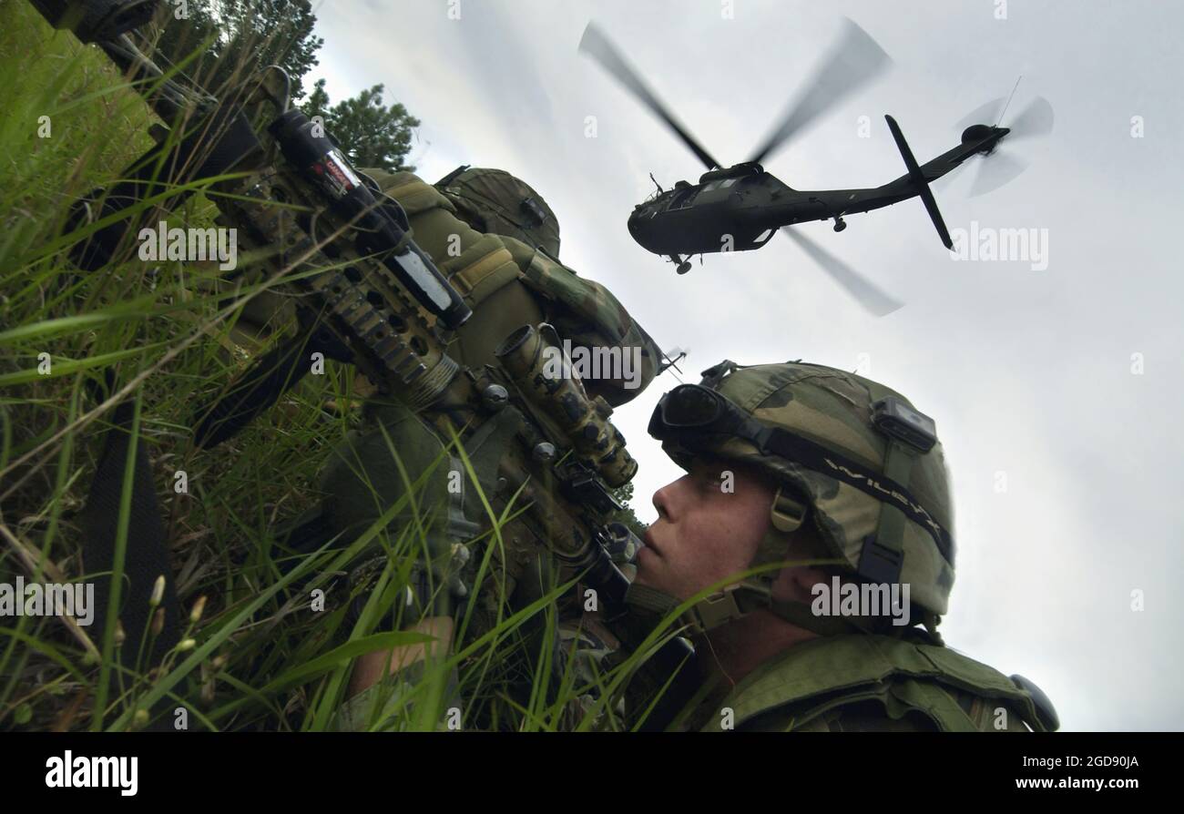 US Army (USA) Private First Class (PFC) Matthew Anderson (Front), Fallschirmjäger, Headquarters and Headquarters Company (HHC), 1. Bataillon (BN), 505. Fallschirmjäger-Infanterie-Regiment (1/505.), 82. Airborne Division (ABN), Richtet eine Perimeterverteidigung ein, nachdem er einen UH-60 Black Hawk (Blackhawk)-Hilfshubschrauber verlassen hat, während er an einer 14-tägigen Übung im Joint Readiness Training Center (JRTC) in Fort Polk, Louisiana (LA), teilnimmt, um den Einsatz seiner Einheit im Irak zur Unterstützung der Operation IRAQI FREEDOM vorzubereiten. (USAF-FOTO VON TSGT CHERIE THURLBY 060412-F-7203T-037) Stockfoto