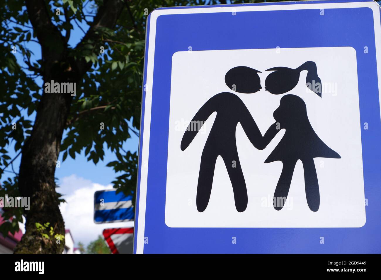 Das Straßenschild ist ein Platz für Küsse in Blau mit dem Bild von Silhouetten gegensätzlichen Geschlechts. Stockfoto