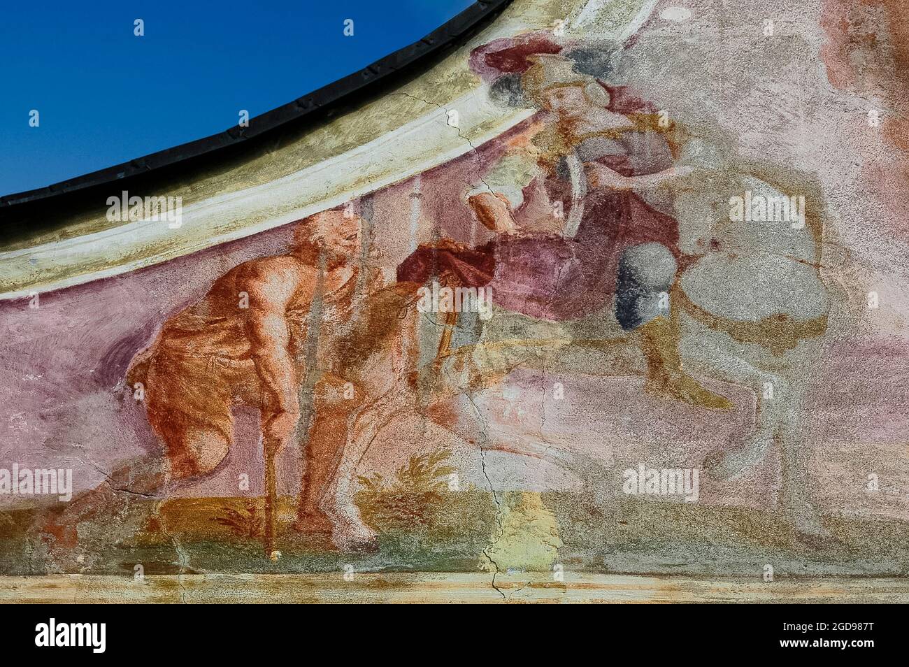 Verblasste Fresken, die dem Kirchenmaler Josef Anton Puellacher (1737-1799) zugeschrieben werden, schmücken den anmutigen Giebel der barocken Ortskapelle oder der Ortskapelle von Fronhausen auf dem Mieminger Plateau, einer bis zu 1,000 m (3,280 ft) hohen Bergterrasse über dem Oberinntal in Nordtirol. Zu den Kunstwerken unter einem holzschindeligen Bellcote gehört die Darstellung des Heiligen Martin von Tours, der seinen Mantel mit einem Bettler teilt. Stockfoto