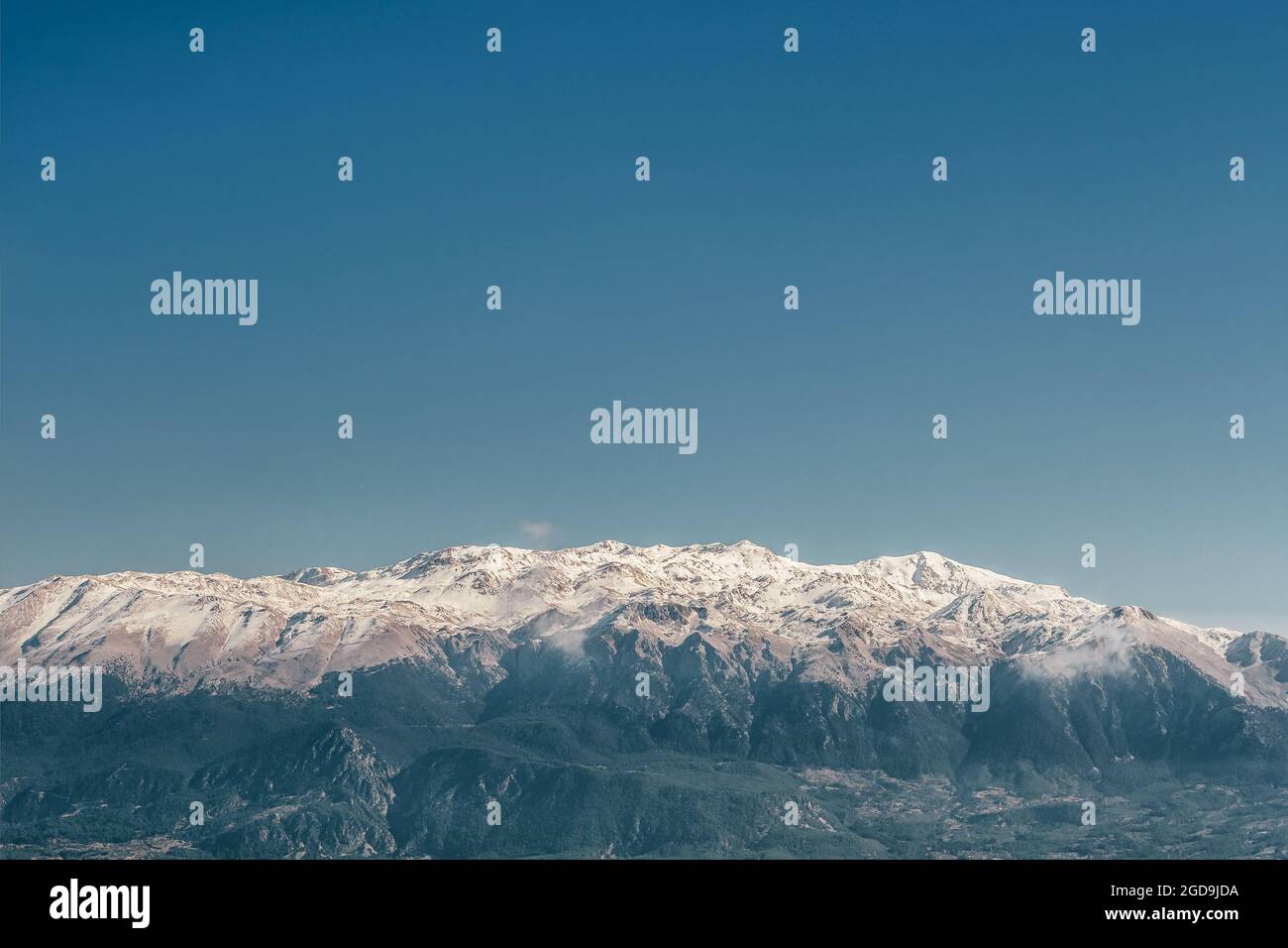 Schneebedeckte Bergkette vor dem tiefblauen Himmel. Stockfoto