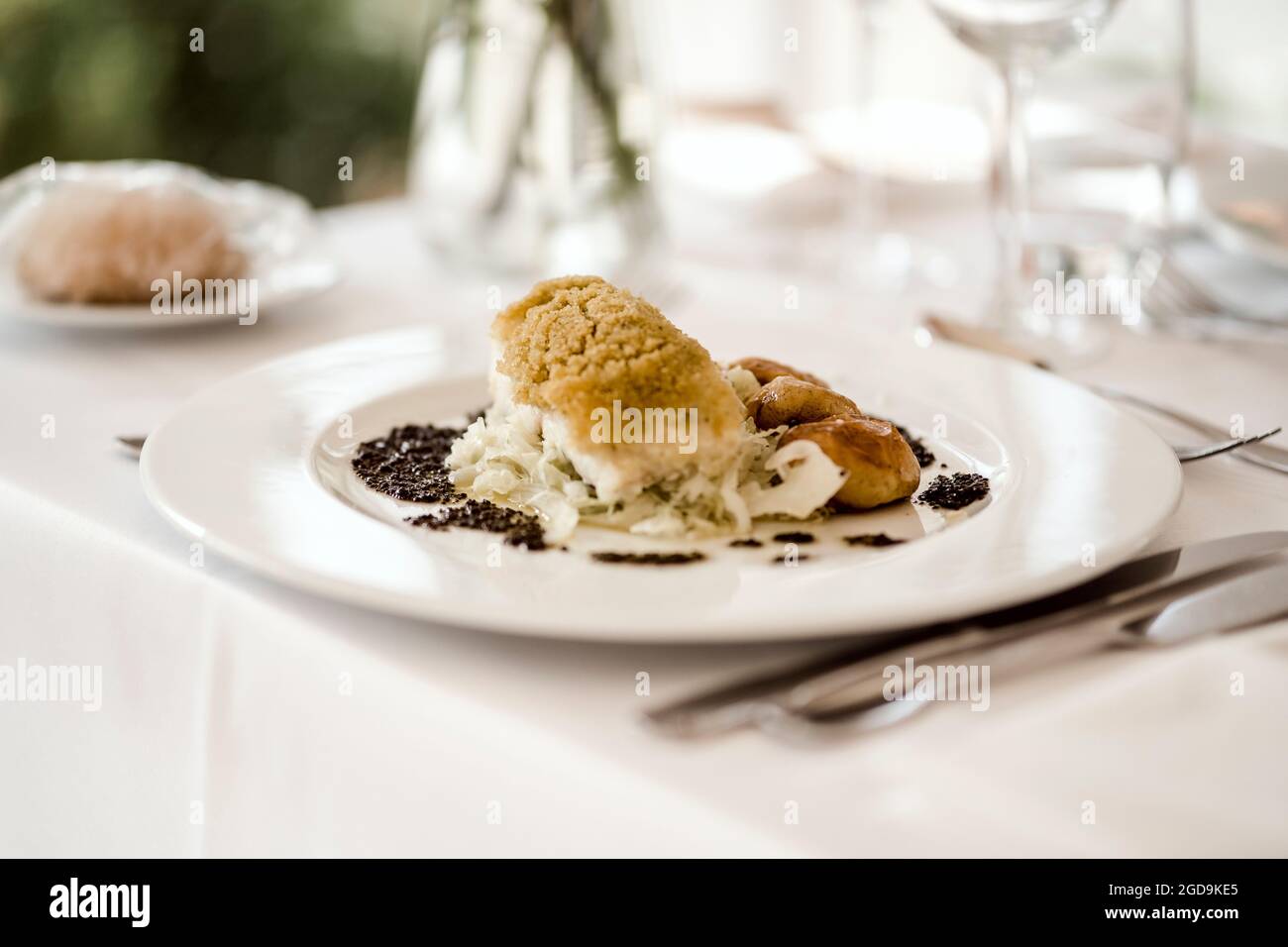 Traditionelle portugiesische Mahlzeit aus gebackenem Kabeljau serviert mit gebackenen Kartoffeln Stockfoto