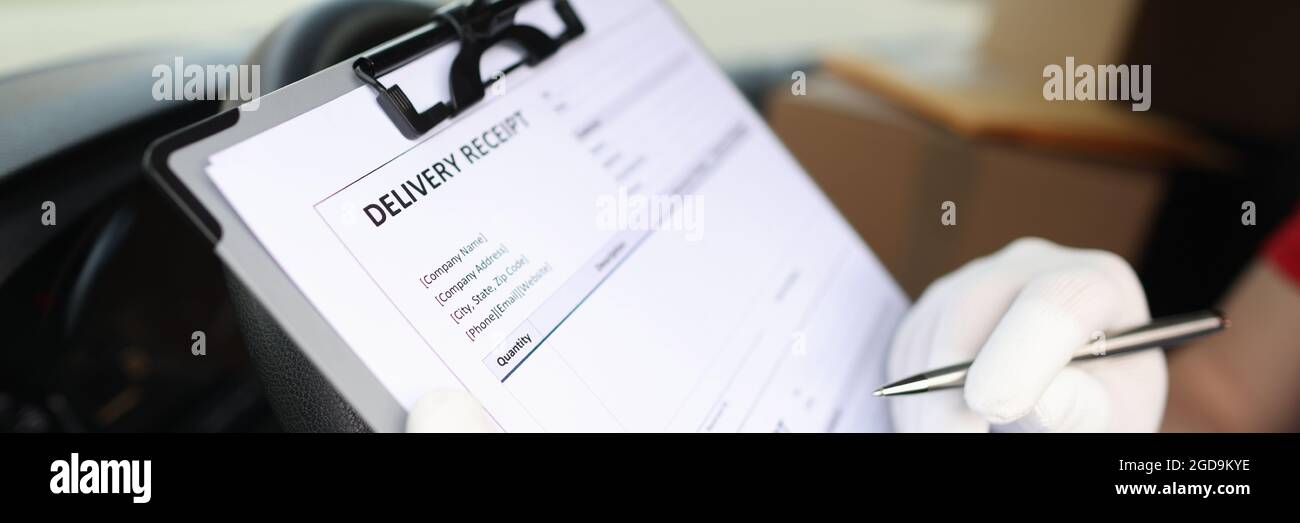 Gloved Courier Ausfüllen Lieferschein mit Kugelschreiber Nahaufnahme Stockfoto
