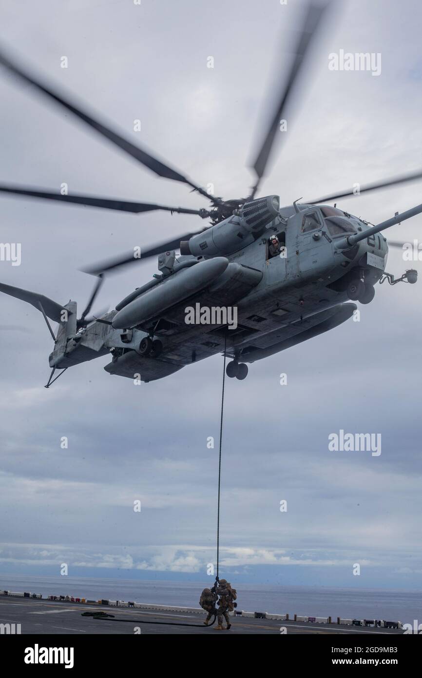 U.S. Marines mit Bataillon Landing Team 3/5, 31. Marine Expeditionary Unit (MEU), Schnellseil an Bord des amphibischen Sturmschiffs USS America (LHA 6) in der Salomonsee, 6. August 2021. Marineinfanteristen trainieren zum schnellen Seil, falls sie rechtzeitig von einem Flugzeug abfliegen müssen oder auf unebenem Gelände landen können. Die 31. MEU ist an Bord von Schiffen der America Expeditionary Strike Group im 7. Einsatzgebiet der Flotte tätig, um die Interoperabilität mit Verbündeten und Partnern zu verbessern und als einsatzbereite Einsatztruppe für Frieden und Stabilität in der Indo-Pazifik-Region zu dienen. (USA Marine Corp Stockfoto