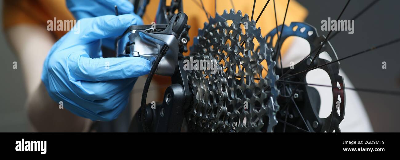 Handwerker in Gummi-Schutzhandschuhen Reparatur Fahrrad Nahaufnahme Stockfoto