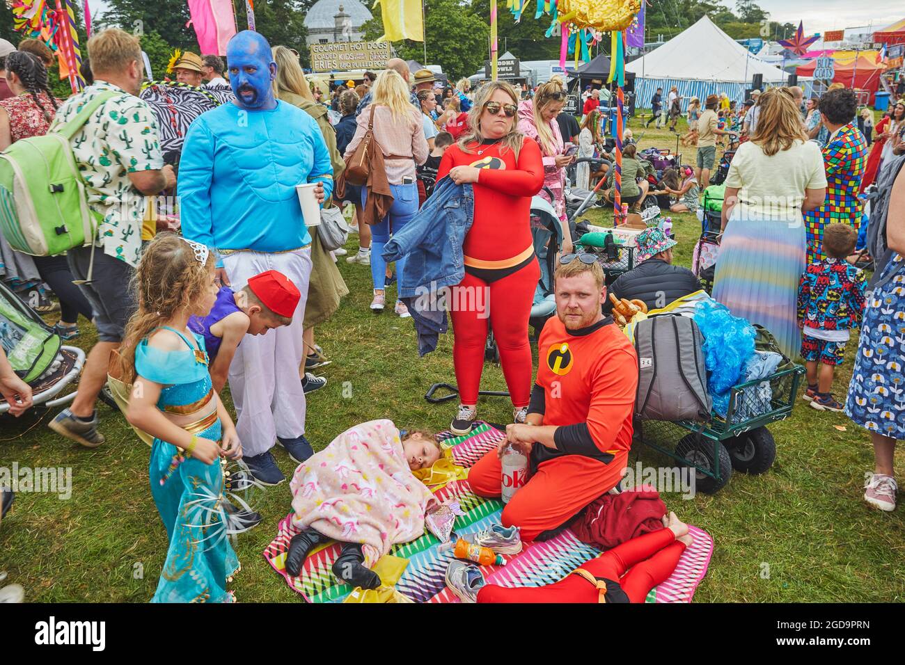 Eine Familie, die bei einem Sommerfest in Superhelden-Kostüme gekleidet ist. Camp Beestival, Lulworth, Dorset, Großbritannien Stockfoto