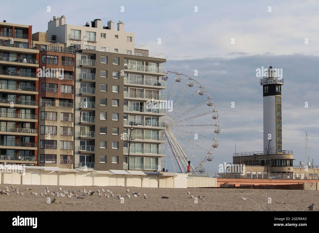 BLANKENBERGE, BELGIEN, 2. AUGUST 2021: Blick auf die Apartments am Meer und das Riesenrad in Blankenberge an einem Sommerabend. Blankenberge ist eine Popula Stockfoto