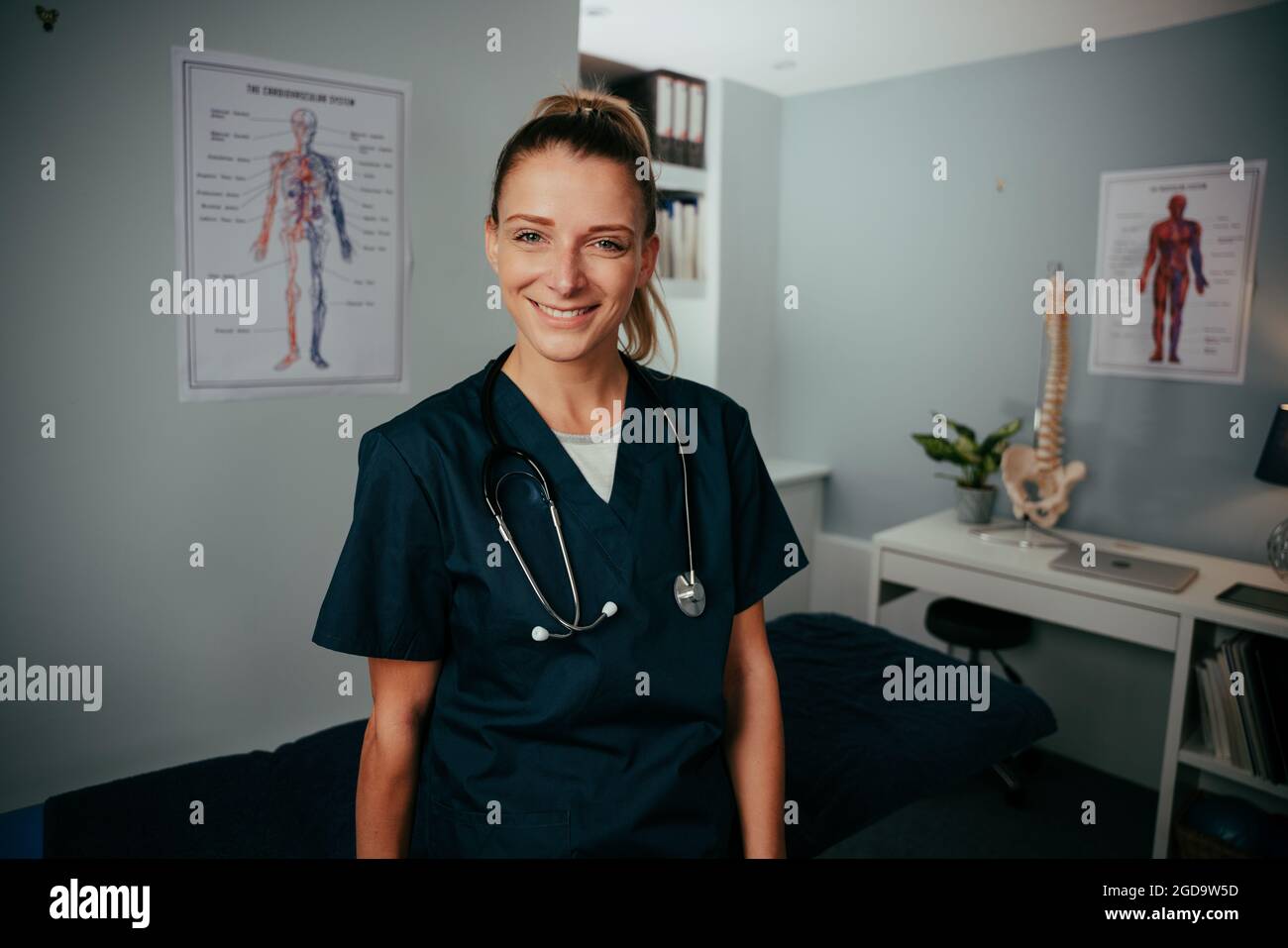 Kaukasische Ärztin, die lächelnd in der Klinik steht Stockfoto