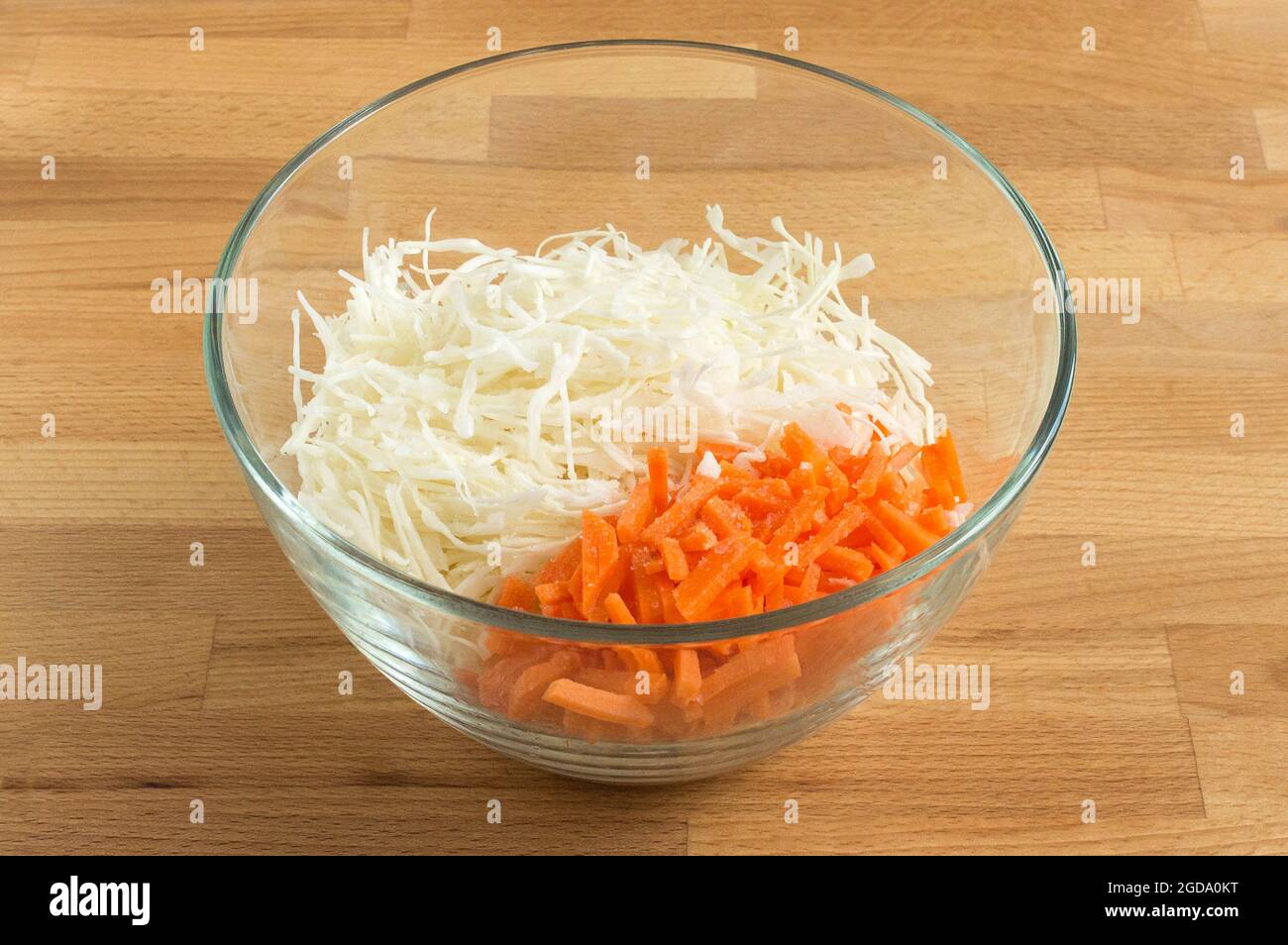 Weißkohl und Karotten in einer transparenten Salatschüssel. Für Salat. Stockfoto
