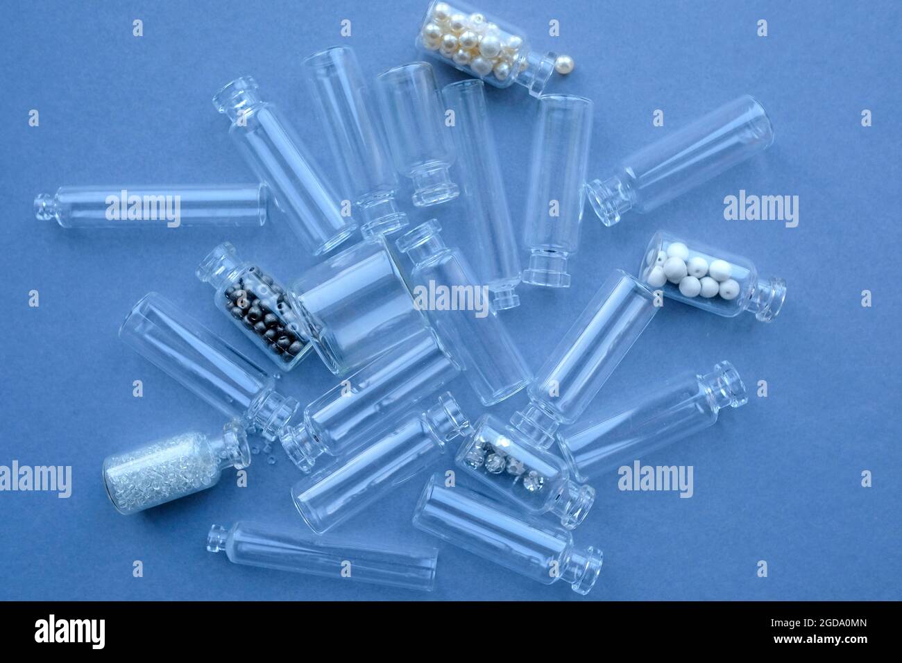 Mehrere kleine Glasflaschen auf bläulichem Hintergrund. Buchiny im Glas. Stockfoto
