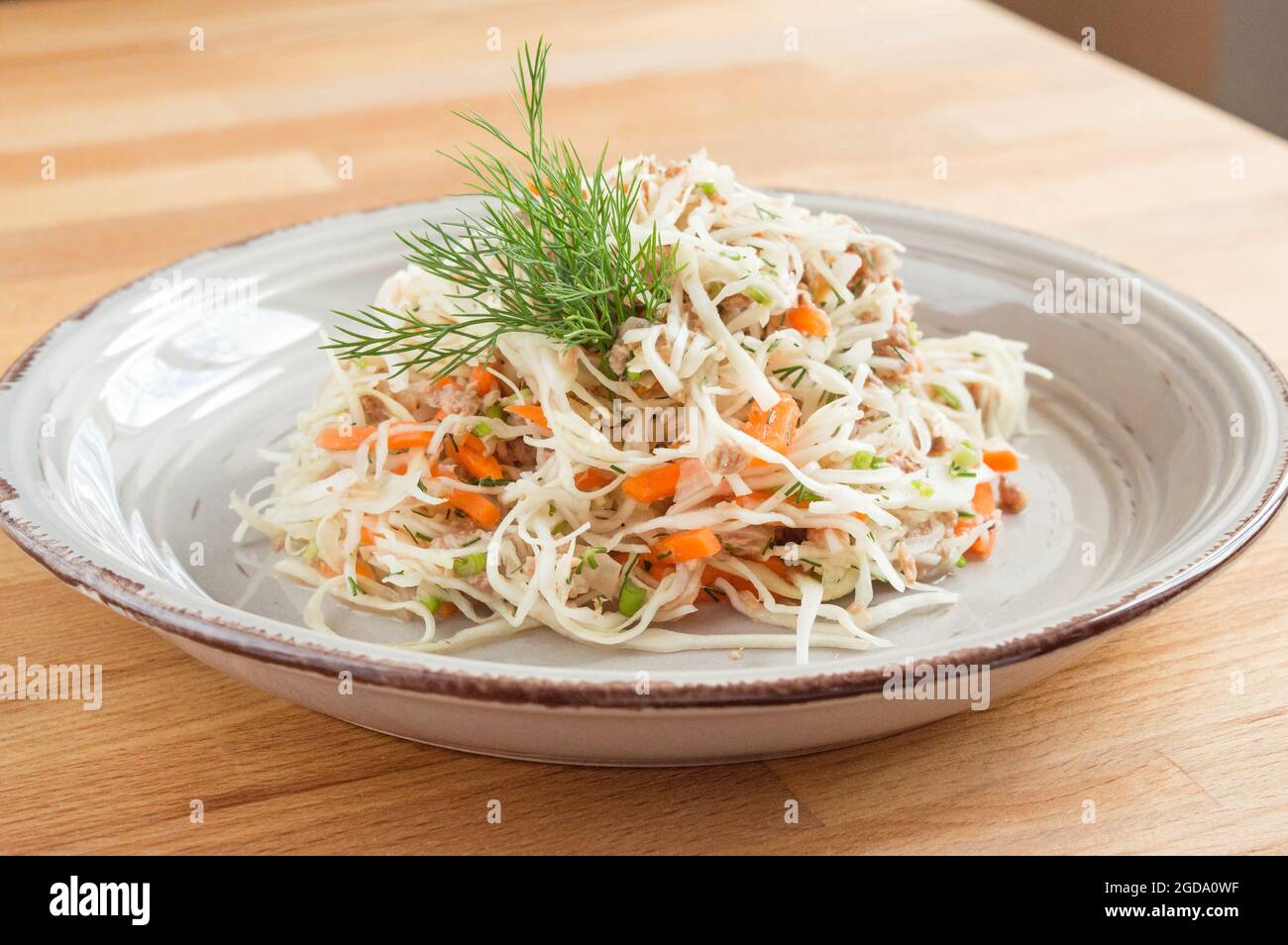 Fertigsalat aus Kohl, Karotten und Fischkonserven. Stockfoto