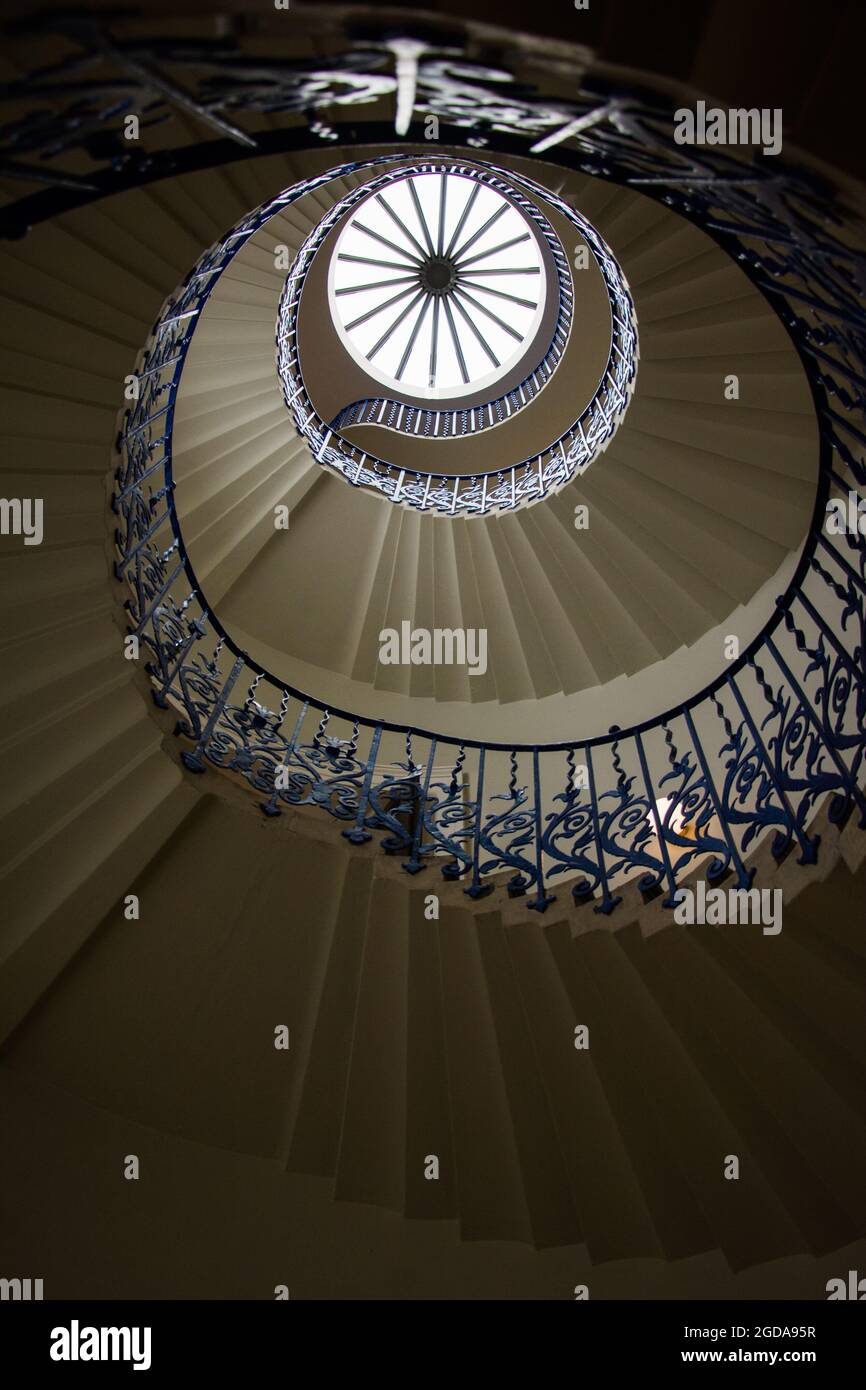 Vertikale Aufnahme der runden Treppe und der Blick auf das Sonnenlicht durch das Glasdach des Gebäudes Stockfoto