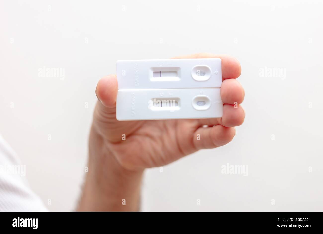 Coronavirus-Selbsttest zu Hause, man Hand mit covid 19 positiven und negativen Ergebnissen Schnelltests, Kits zum Nachweis von Antikörpern. Infektion und Immuni Stockfoto