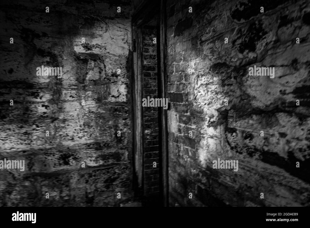 Gruselig aussehende Tür in einem alten verlassenen Fort ives schwarz-weiß Foto Stockfoto