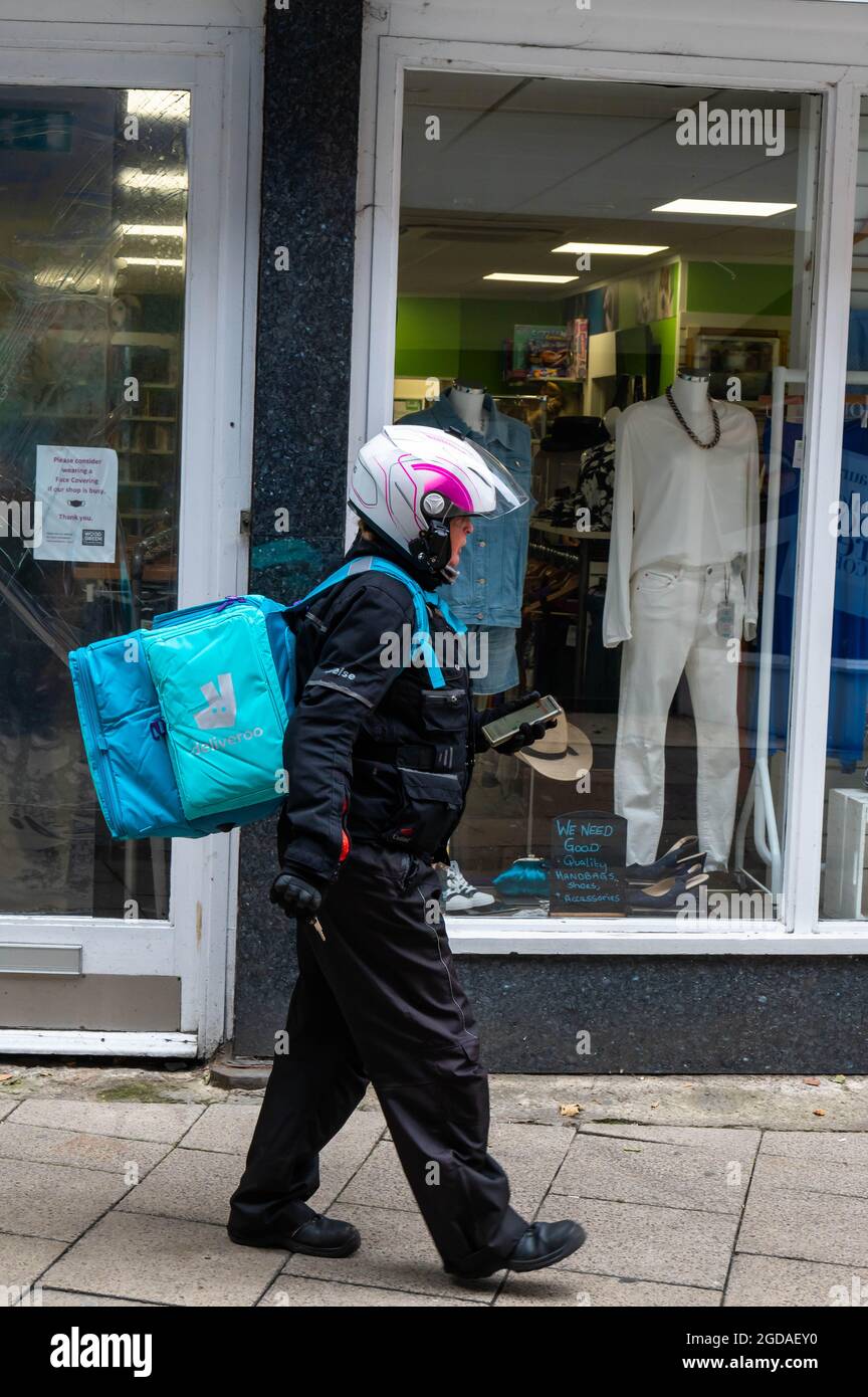 Deliveroo Motorradfahrer, der in Richtung einer Essensabholung im Stadtzentrum von Norwich geht Stockfoto