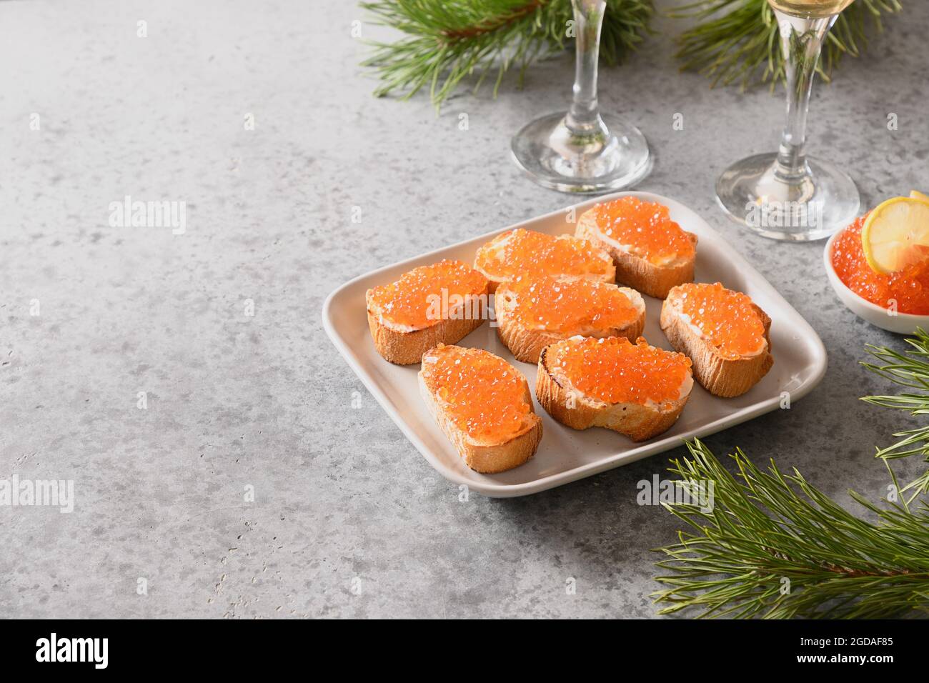 Vorspeise Canape von Ciabatta mit rotem Kaviar auf grauen Stein Tisch. Weihnachten, Neujahrsfeiertage. Festliche Speisen. Nahaufnahme. Stockfoto