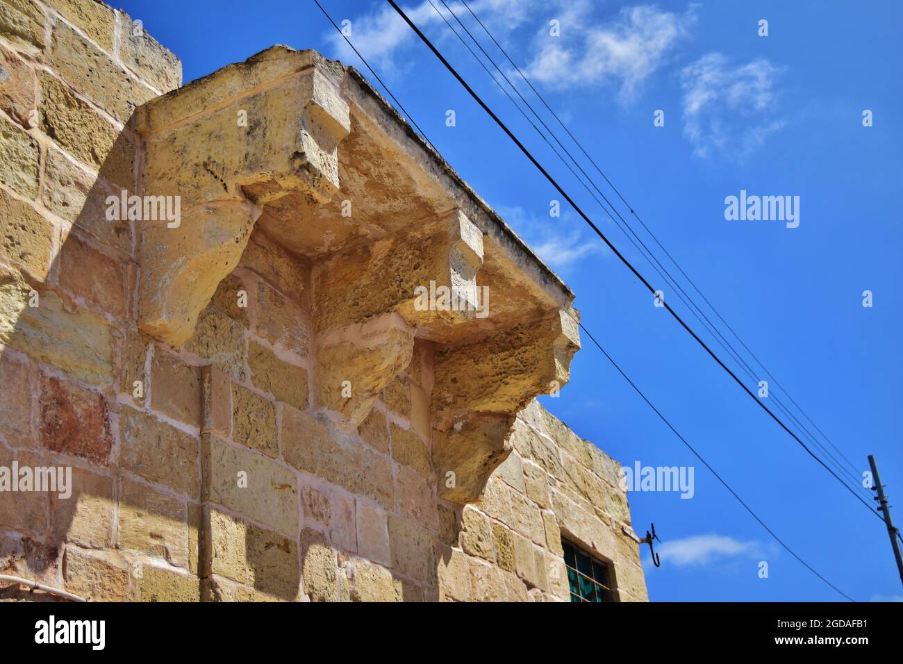 KALAKARA, MALTA - Apr 01, 2015: Eine einfache Kalkstein-Balkonstützenhalterung, Saljaturi, auf der Dachebene eines kleinen Kalksteingebäudes in Kalk gebaut Stockfoto