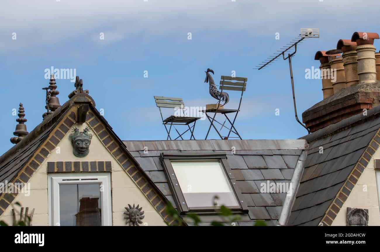 Metallcockerschale auf einem Metallstuhl auf einem Dach ausbalanciert Stockfoto